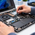 Technician repairing an open laptop
